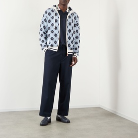 Model wearing Casablanca Monogram Logo Zip Sweatshirt in CC Monogram, styled with navy wide-leg trousers and black loafers.