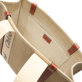 Chlo&eacute; tote bag interior view in white and brown, showing canvas lining, branded panel, and tan leather trim details