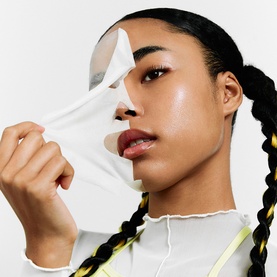 Model with Dr Jart Ceramidin Skin Barrier Moisturising Sheet Mask, peeling white sheet mask away from face to reveal glowing skin