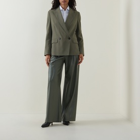 Model wearing Hugo Boss blazer in khaki green, double-breasted, paired with wide-leg trousers and black heels.
