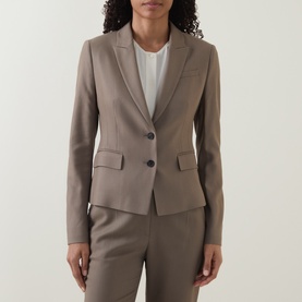 Model wearing taupe two-button blazer with notch lapels and flap pockets, styled with matching tailored trousers and white top.