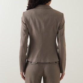 Model wearing a taupe tailored blazer, rear view, with matching trousers, featuring button cuff detail and structured silhouette