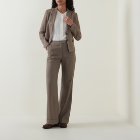 Model wearing taupe wide-leg trousers and matching blazer with white top and brown loafers