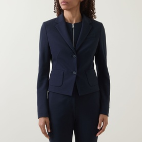 Model wearing navy tailored blazer with notch lapel, two-button fastening and welt pockets, styled with matching navy trousers
