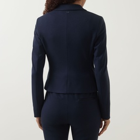 Model wearing a navy tailored blazer, rear view, styled with matching navy trousers