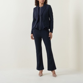 Model wearing navy zip-front peplum blazer styled with matching navy flared trousers and nude heels