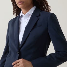 Model wearing Hugo Boss dark blue virgin wool blazer with notch lapel and single button fastening, styled with a white shirt.