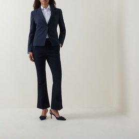 Model wearing Hugo Boss dark blue virgin wool blazer with matching flared trousers, white shirt and navy heels.