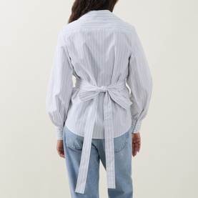 Model wearing Hugo Boss light purple striped cotton blouse, back view showing self-tie belt detail, styled with light blue jeans