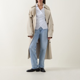 Model wearing Hugo Boss light purple cotton blouse, styled with beige trench coat, light blue wide-leg jeans and black loafers