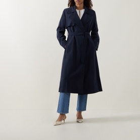 Model wearing Hugo Boss dark blue viscose trench coat with tie belt, styled with wide-leg jeans and cream heels