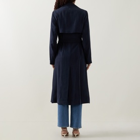Model wearing Hugo Boss dark blue viscose trench coat, rear view, with contrast belt and wide lapels, styled with blue wide-leg jeans