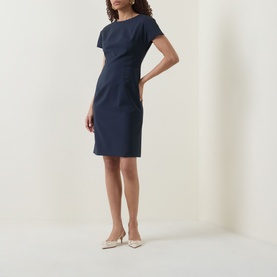 Model wearing Hugo Boss dark blue wool sheath dress with cap sleeves and boat neckline, styled with cream pointed-toe heels
