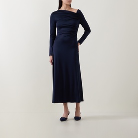 Model wearing Hugo Boss dark blue midi dress with asymmetric neckline, ruched waist, and long sleeves, styled with navy heels.
