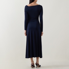 Model wearing Hugo Boss dark blue long-sleeve midi dress, back view, showing boat neck and flared skirt, styled with black heels.