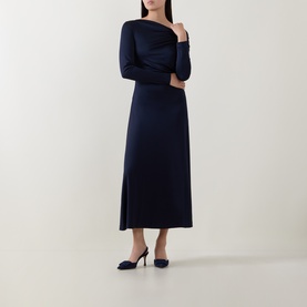Model wearing Hugo Boss dark blue midi dress with long sleeves and asymmetric neckline, styled with navy heeled mules