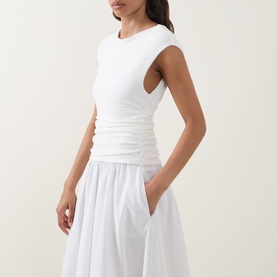 Model wearing Hugo Boss white dress with ruched bodice detail and full cotton skirt, styled in a clean minimal look