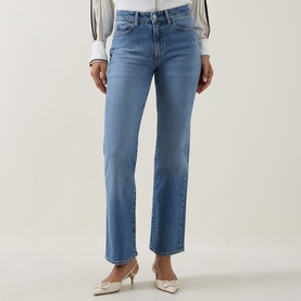Model wearing Hugo Boss medium blue straight-leg jeans, styled with a white blouse and cream heeled mules.