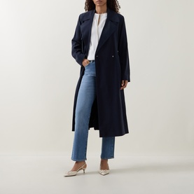 Model wearing Hugo Boss medium blue straight-leg jeans, styled with a navy longline coat and cream heels.