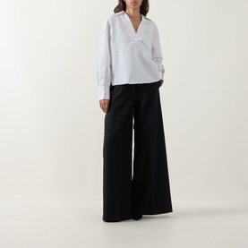 Model wearing Hugo Boss Batala Stripe Open Placket Shirt in Open White with V-neckline and long sleeves, styled with wide-leg black trousers.