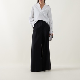 Model wearing Hugo Boss Batala Stripe Open Placket Shirt in Open White with V-neckline and long sleeves, styled with wide-leg black trousers.