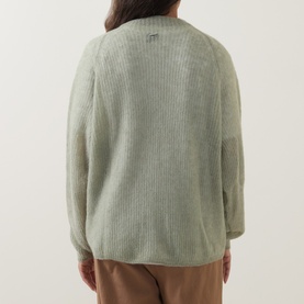Model wearing Hugo Boss Fewena Brushed Sweater in Open Green, rib-knit construction with brushed finish, back view, styled with tan trousers