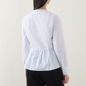 Model wearing Hugo Boss Beplum Collarless White Shirt, back view showing gathered waist detail and flared hem, paired with black trousers.
