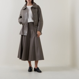 Model wearing Hugo Boss Brown Overflow leather midi skirt with matching jacket, white top and black loafers.