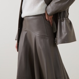 Model wearing Hugo Boss Brown Overflow leather midi skirt with flared hem, styled with matching leather jacket and white knit top.