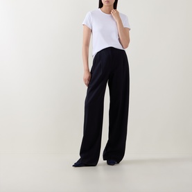 Model wearing Hugo Boss white cotton-modal-silk top with wide-leg navy trousers.
