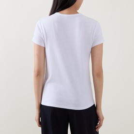 Model wearing Hugo Boss white short-sleeve top, back view, with navy trousers. Cotton, modal and silk blend.