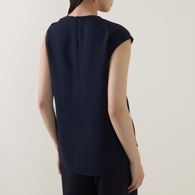 Model wearing Hugo Boss Bannea Draped Top in dark blue, showing rear half zip fastening, sleeveless design and curved hem
