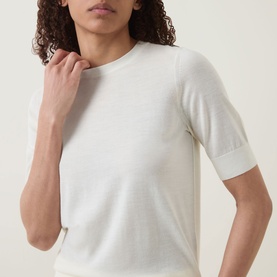 Model wearing Hugo Boss Farbella Knit Top in Open Beige, crew neck, short sleeves with ribbed trims, 100% virgin wool knit