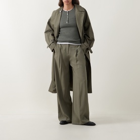 Model wearing Hugo Boss dark green wool top styled with matching wide-leg trousers and longline coat in olive tones