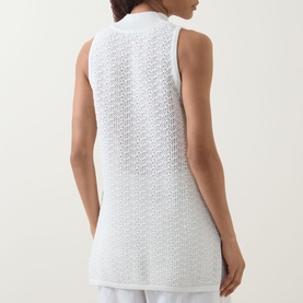 Model wearing Hugo Boss Open White sleeveless cotton crochet-knit top, shown from the back, collarless neckline, longline fit.