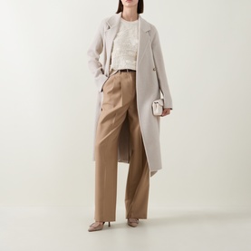 Model wearing Hugo Boss Open White top with stone longline coat, tan wide-leg trousers, and nude heels, carrying small white bag.