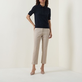 Model wearing Hugo Boss dark blue short-sleeve wool polo top with beige cropped trousers and nude heels.