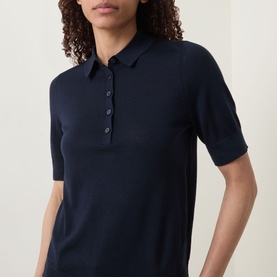 Model wearing Hugo Boss dark blue virgin wool polo top with short sleeves and button placket, styled close-up at neckline.