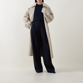 Model wearing Hugo Boss Dark Blue wool top styled with beige trench coat and wide-leg navy trousers.
