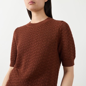 Model wearing Hugo Boss rust/copper cotton knit short-sleeve top with textured open-weave pattern and crew neck.