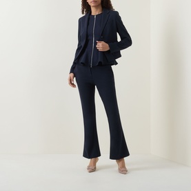Model wearing navy zip-front peplum blazer styled with matching navy flared trousers and nude heels