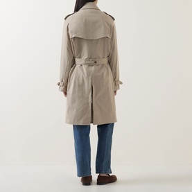 Model wearing Hugo Boss Caomy Double-Breasted Trench Coat in Beige Overflow, rear view showing belt, back vent and epaulettes, styled with blue jeans