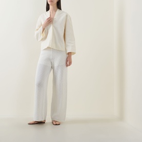 Model wearing Hugo Boss Fangrove Knitted Wide-Leg Trousers in Open White, textured knit, high-rise, styled with cream top and tan sandals