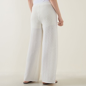 Model wearing Hugo Boss Fangrove Knitted Wide-Leg Trousers in Open White, showing textured knit, high-rise waist and wide-leg silhouette from behind.