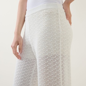 Model wearing Hugo Boss Fangrove Knitted Wide-Leg Trousers in Open White, showing textured open-knit cotton fabric and elasticated waistband