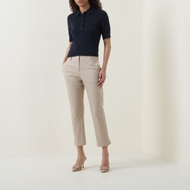Model wearing Hugo Boss Beige Overflow cropped trousers in cotton blend, styled with navy polo shirt and nude heels.