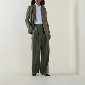 Model wearing Hugo Boss dark green wide-leg trousers, styled with a matching blazer and white shirt, black pointed-toe flats.