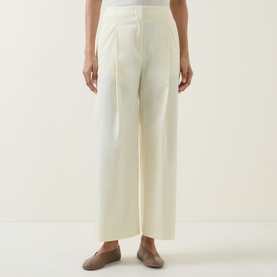 Model wearing Hugo Boss open beige wide-leg trousers in cotton blend, styled with taupe flat shoes