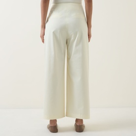 Model wearing Hugo Boss open beige wide-leg cotton trousers, rear view, styled with tan flat shoes.