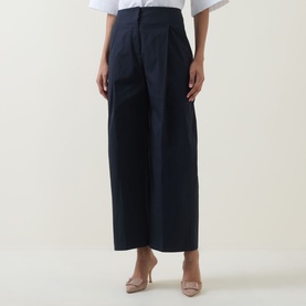 Model wearing Hugo Boss dark blue wide-leg cotton trousers with front pleats, styled with a white top and nude heels.